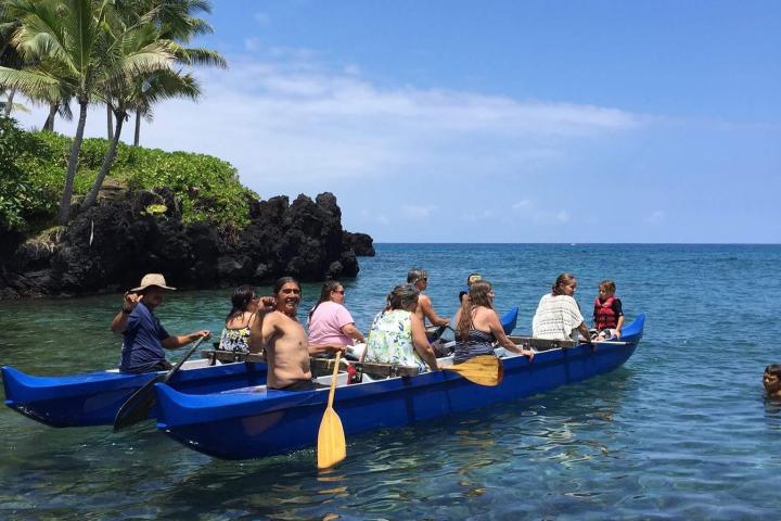 a group of people in a small boat in a body of water
