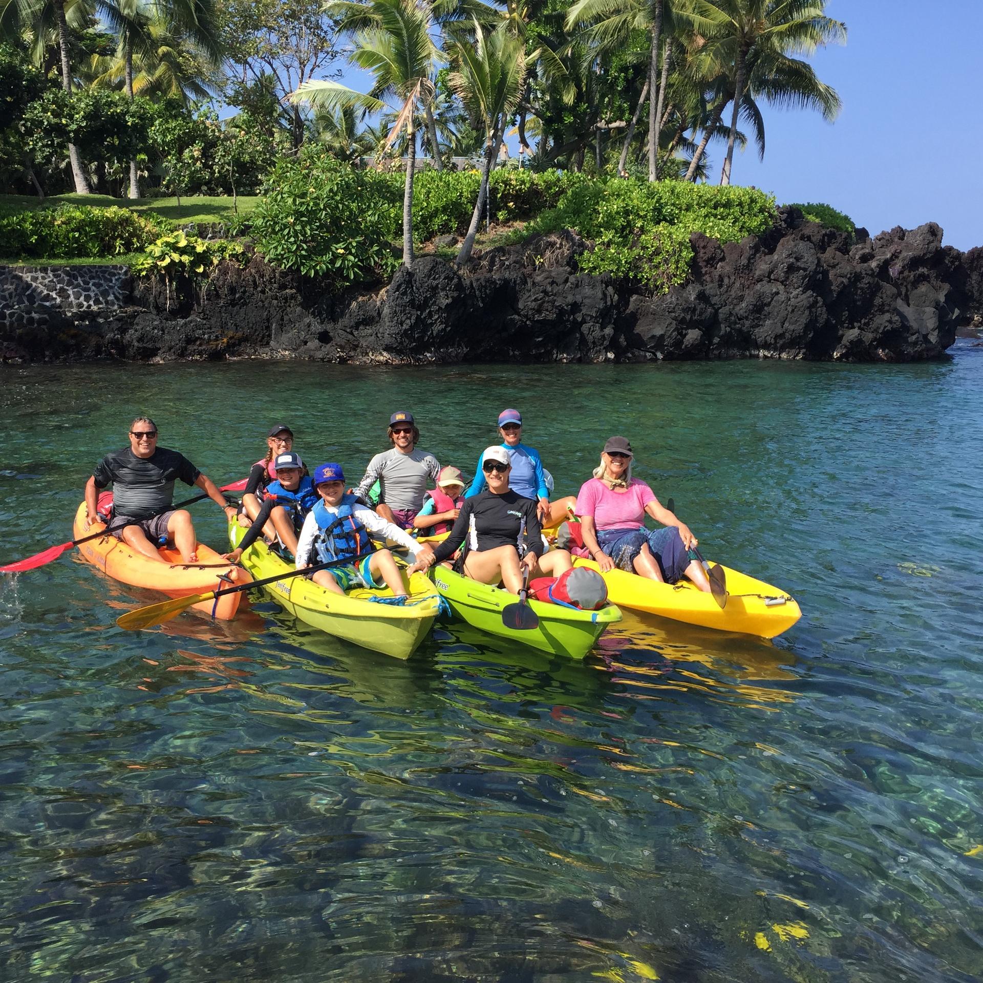 a group of people riding on the back of a boat in the water