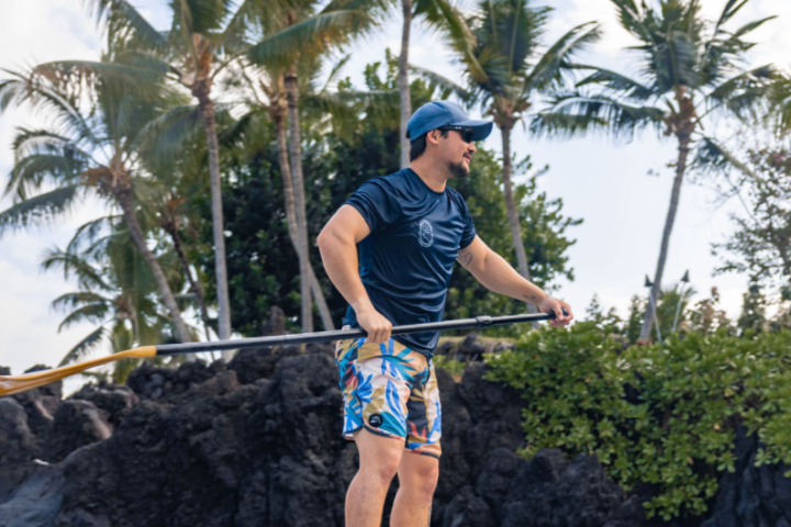 a man standing next to a palm tree