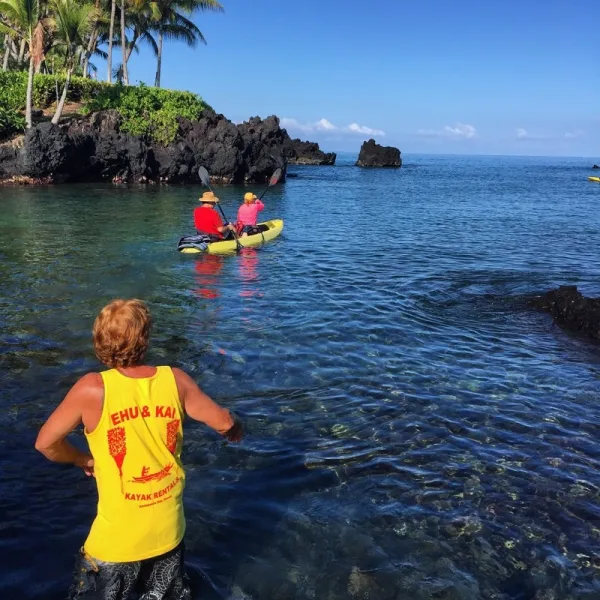a group of people standing next to a body of water