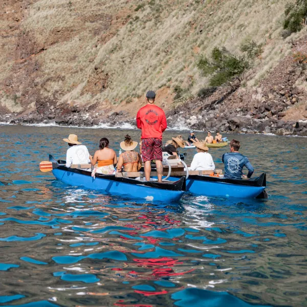 a group of people in a small boat in a body of water